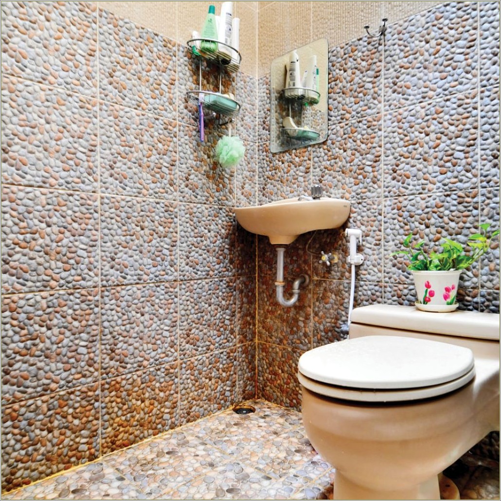 Penggunaan keramik motif batu kerikil bisa menghadirkan tampilan earthy di kamar mandi.
