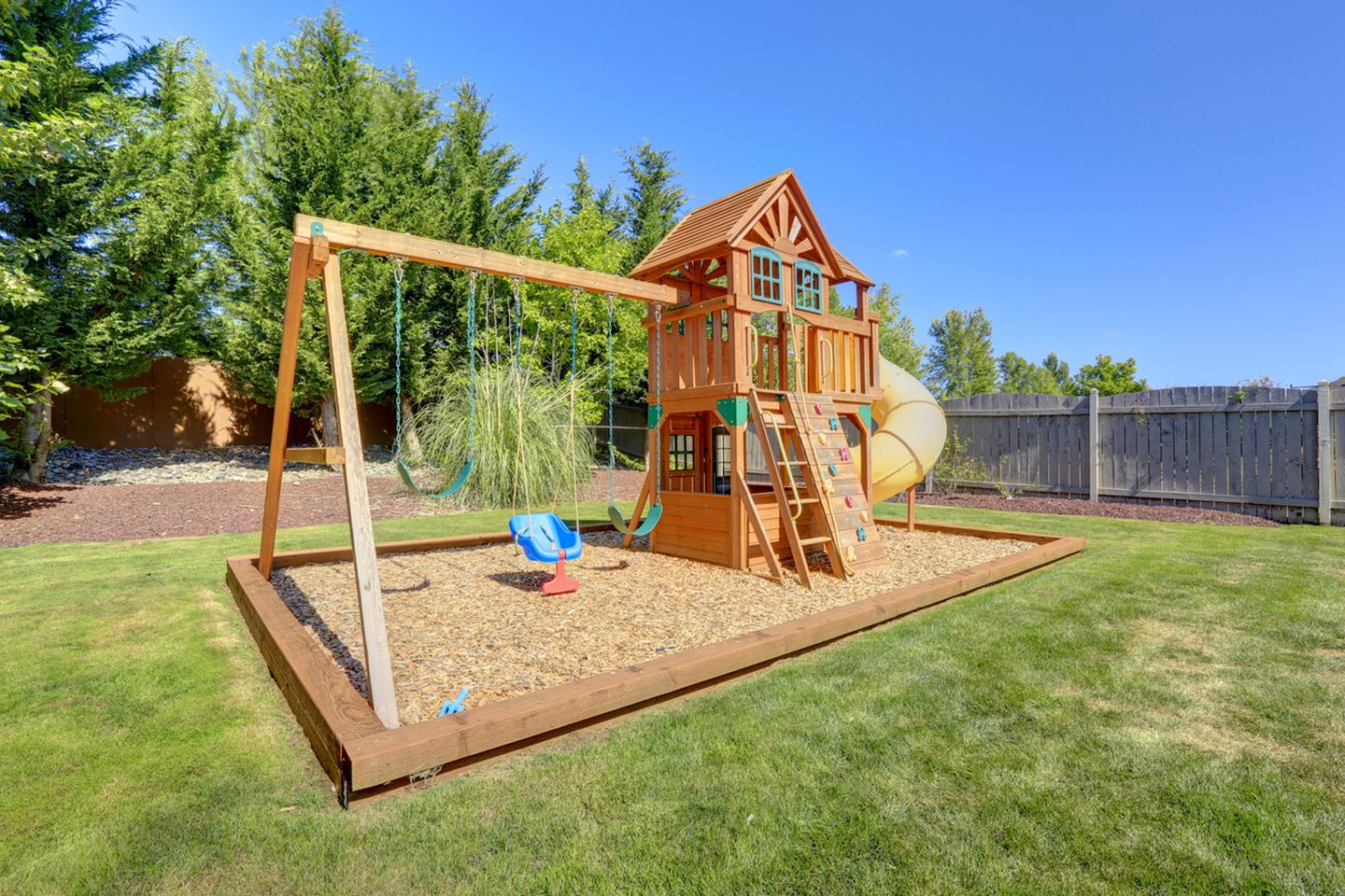 Desain taman belakang dengan playground bisa menjadi tempat wisata mini untuk anak-anak.